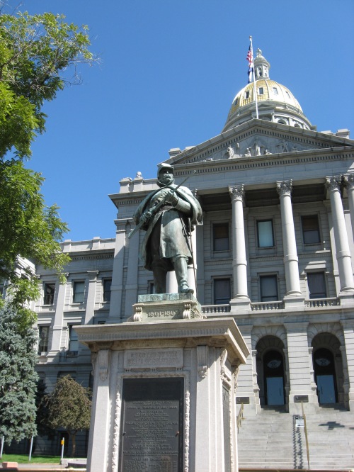 An average statue in front of an average state capitol. 